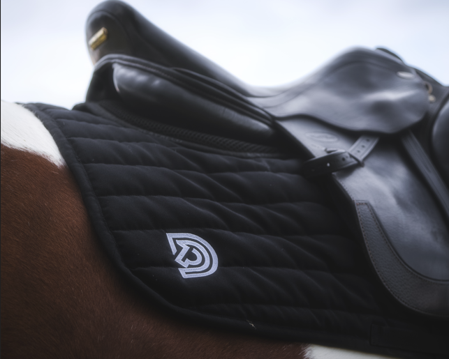 Serra saddle pad in Obsidian placed under saddle on horse